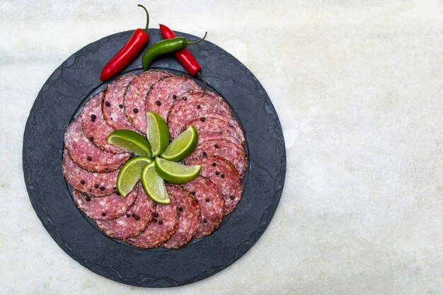 Portion de salami sur plaque de pierre noire