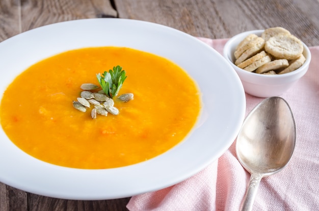 Portion de soupe à la citrouille sur la table en bois