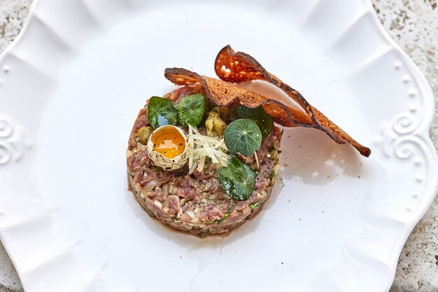 Portion de tartare de thon sur plaque blanche, vue de dessus