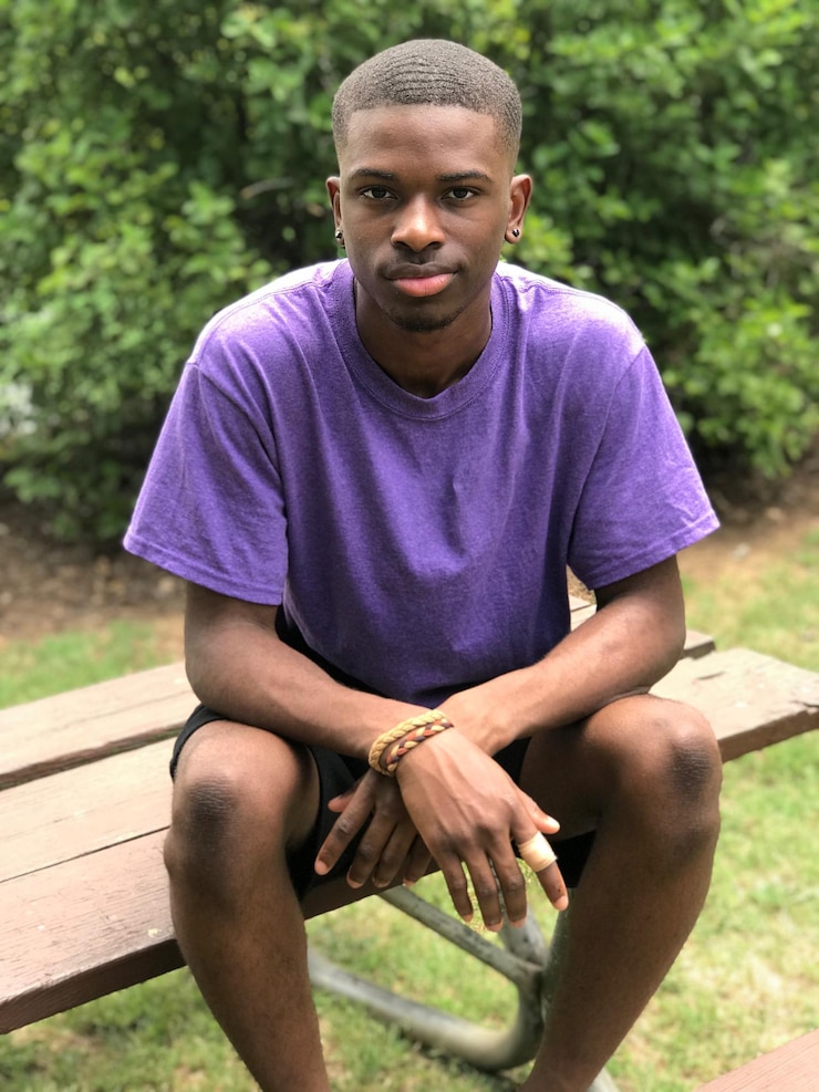 Photo portrait d'un adolescent assis sur un banc du parc