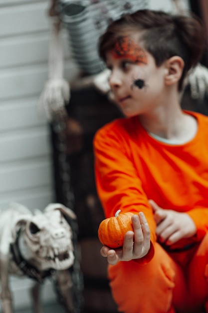 Portrait d'un adolescent candide et authentique avec un visage peint lors d'une fête de squelettes décorés d'Halloween