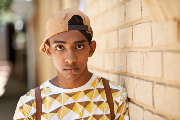 Portrait d'un adolescent debout près d'un mur