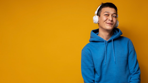 Photo portrait d'un adolescent écoutant de la musique et souriant