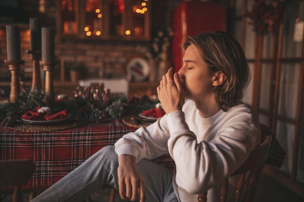 Portrait d'adolescent garçon rêveur authentique candide dans la tristesse déprimant l'émotion à la maison Noël