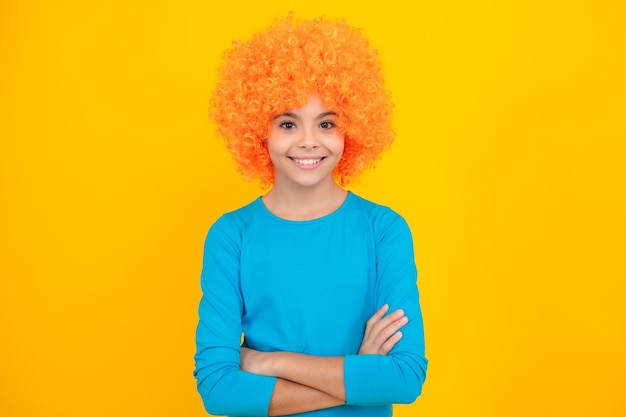 Portrait d'adolescent heureux adolescente avec perruque jaune enfant drôle portant des cheveux perruque bouclée orange fille souriante