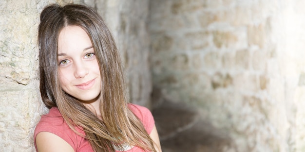 Photo portrait de l'adolescent mignon beauté fille contre les anciens rochers du vieux mur extérieur