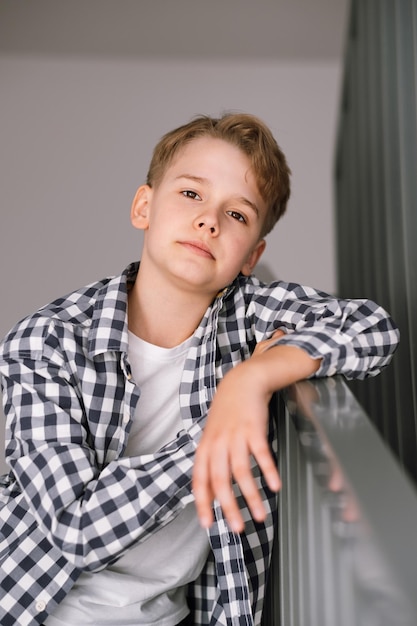 Portrait d'un adolescent moderne regardant la caméra Le gars est assis sur les marches