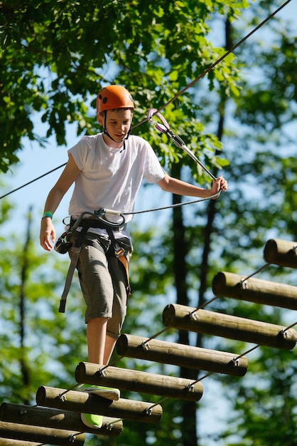 Portrait d'un adolescent s'amusant dans un parc de corde d'aventure extrême en plein air Enfants actifs dans la nature