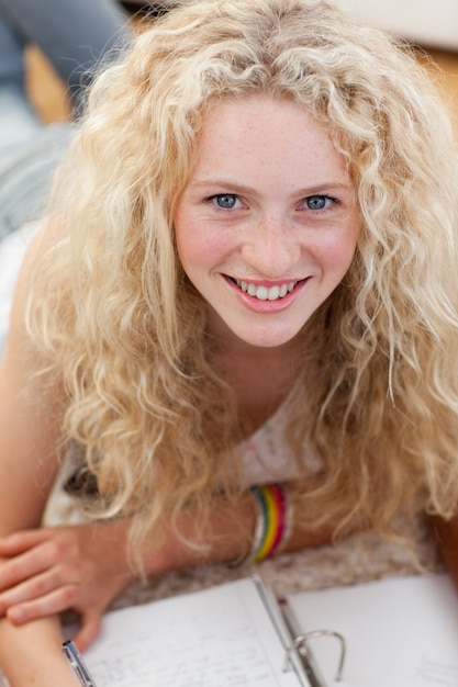 Photo portrait d'un adolescent souriant étudie sur le sol