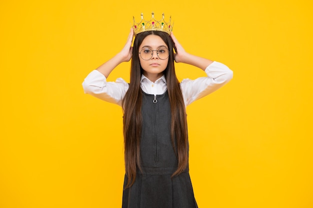 Portrait d'une adolescente ambitieuse avec une couronne sentiment de confiance princesse couronne de princesse enfant sur fond de studio isolé