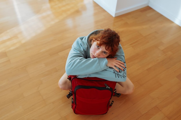 Portrait d'une adolescente attrayante avec une valise et un chat dans un appartement vide