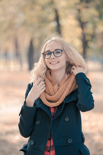 Portrait d'une adolescente dans de grandes lunettes noires dans un parc d'automne