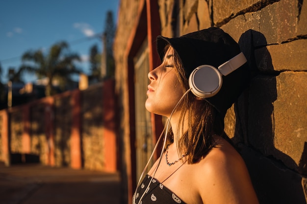 Portrait d'une adolescente écoutant de la musique les yeux fermés.