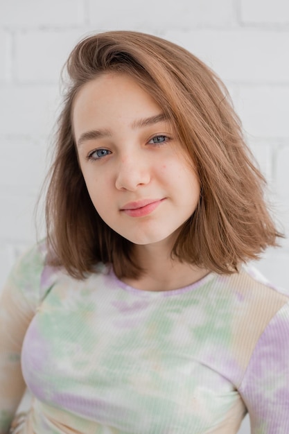 Portrait d'une adolescente élancée dans un col roulé léger à la lumière naturelle contre un mur de briques blanches. beauté naturelle, pas de maquillage. peau problématique. espace pour le texte. Photo de haute qualité