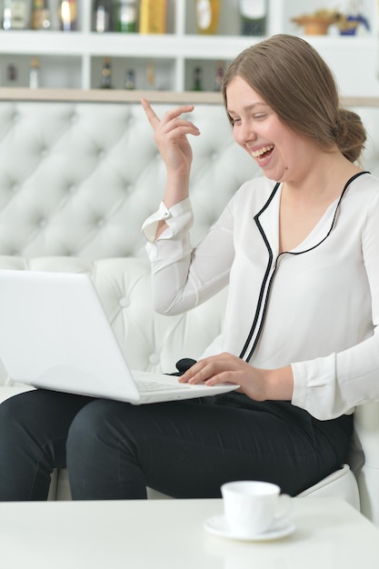Portrait d'une adolescente émotionnelle à l'aide d'un ordinateur portable en position assise