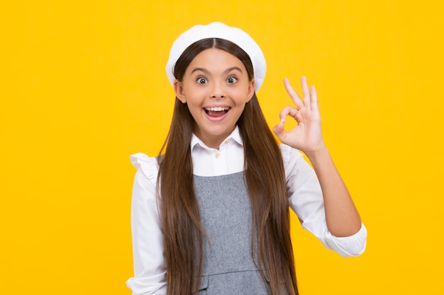 Portrait d'une adolescente faisant un geste ok fond isolé Jeune adolescent souriant et donnant un signe okey