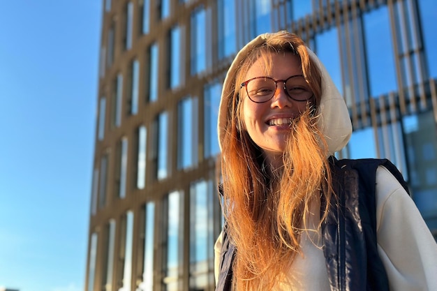 Portrait d'une adolescente heureuse ou d'une jeune femme étudiante universitaire ou collégiale dans des lunettes à l'extérieur