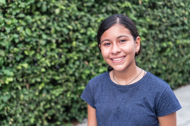Portrait d'une adolescente hispanique souriant à l'extérieur