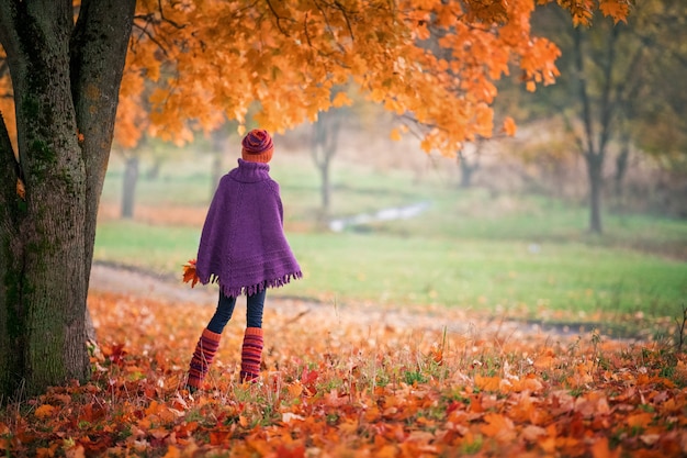 Portrait d'une adolescente marchant dans un parc d'automne