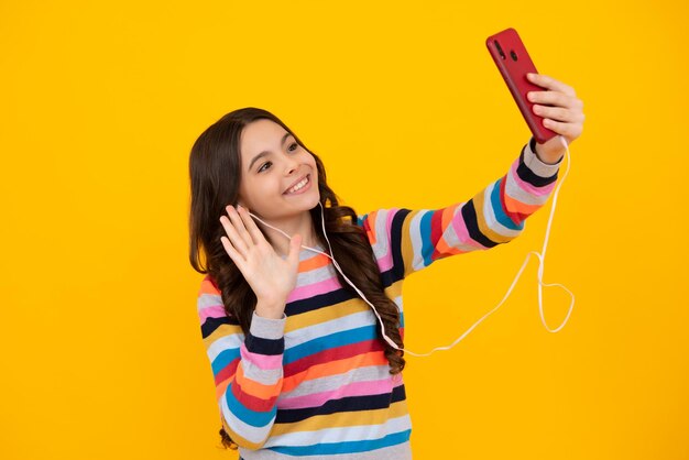 Portrait d'une adolescente mignonne utilisant un téléphone portable pour discuter sur le web en tapant un message sms Application mobile pour smartphone