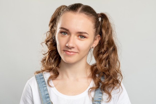 Portrait d'une adolescente Mode de vie des jeunes Femme heureuse avec 2 queues de cheval coiffure mignonne souriante isolée sur fond neutre Beauté de la tendresse