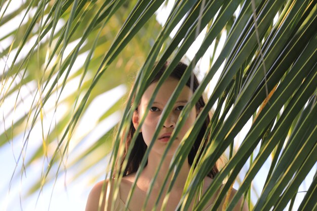portrait d'une adolescente par un palmier