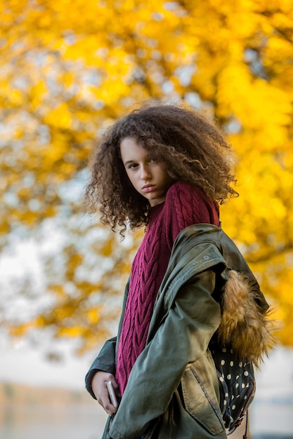 Portrait d'une adolescente posant dans un parc d'automne