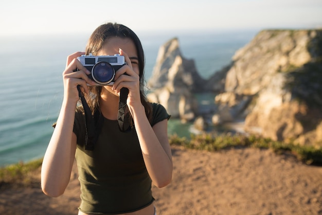 Portrait d'une adolescente prenant une photo avec un appareil photo