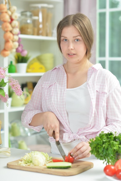 Portrait d'une adolescente préparant une salade fraîche