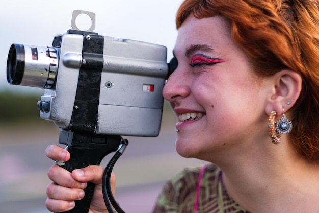 Portrait d'une adolescente de profil tenant une caméra vidéo
