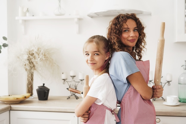 Photo portrait d'une adolescente avec sa mère à la maison dans la cuisine