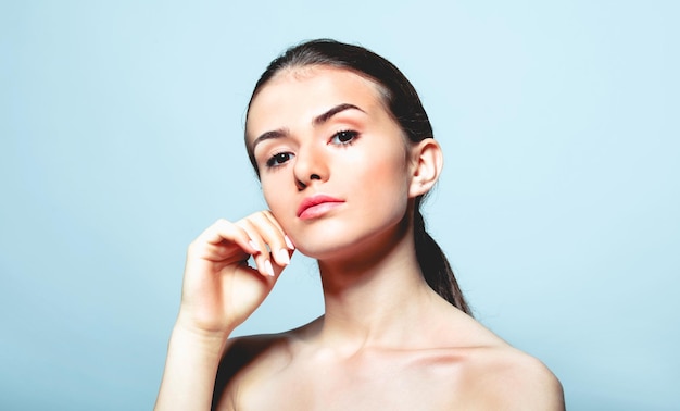 Portrait d'une adolescente sans chemise sur un fond bleu