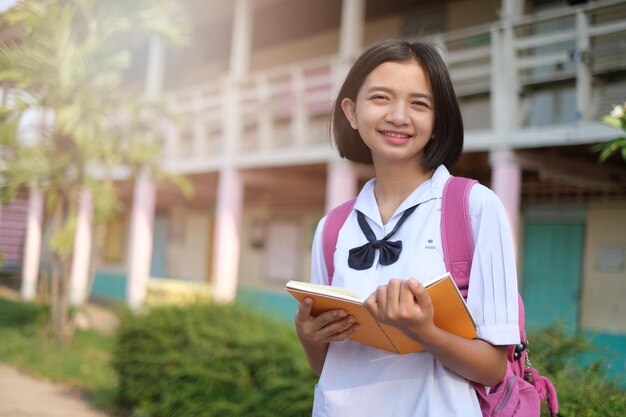 Photo portrait d'une adolescente souriante debout à l'extérieur