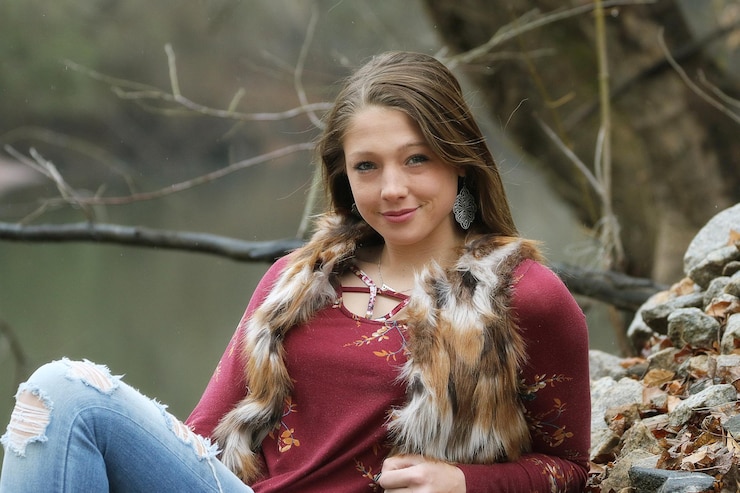Photo portrait d'une adolescente souriante penchée à l'extérieur