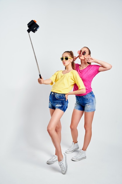 Portrait d'adolescents heureux prenant selfie ensemble isolé sur blancportrait d'adolescents heureux en vêtements d'été lunettes de soleil prenant selfie ensemble isolé sur blanc