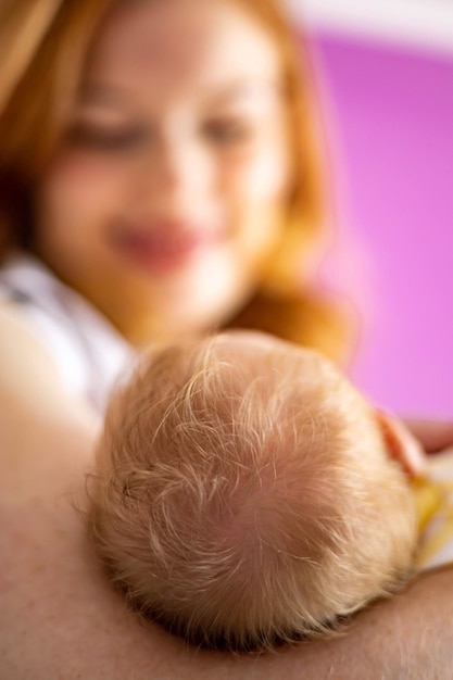 Portrait adorable mère rousse souriante posant avec un nouveau-né sentiment d'amour appréciant la maternité