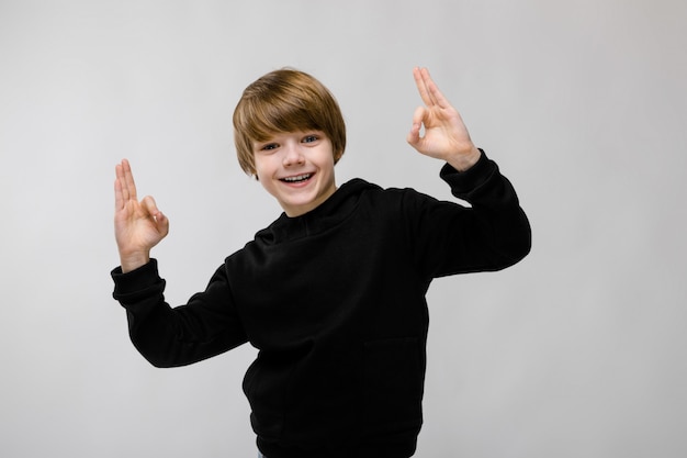 Portrait, de, adorable, petit, souriant, garçon, debout, studio, montrer, signe ok, sur, fond gris