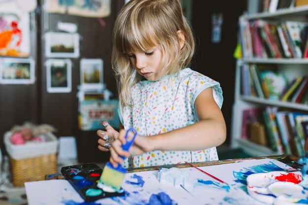 Portrait de l'adorable petite fille peinture à la maison