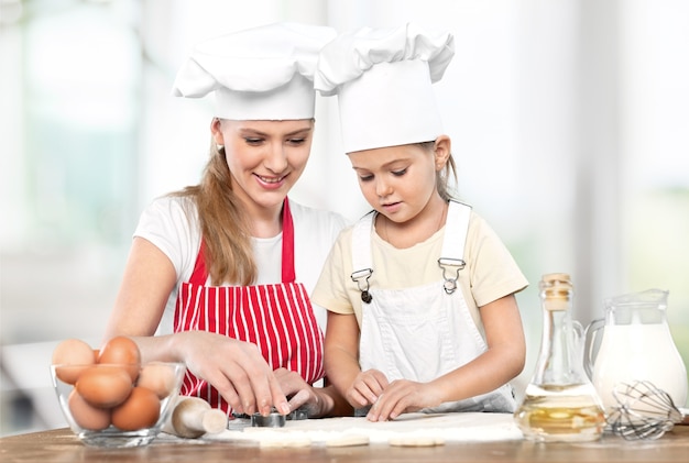 Portrait d'une adorable petite fille et de sa mère cuisinant ensemble