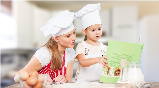 Portrait d'une adorable petite fille et de sa mère cuisinant ensemble