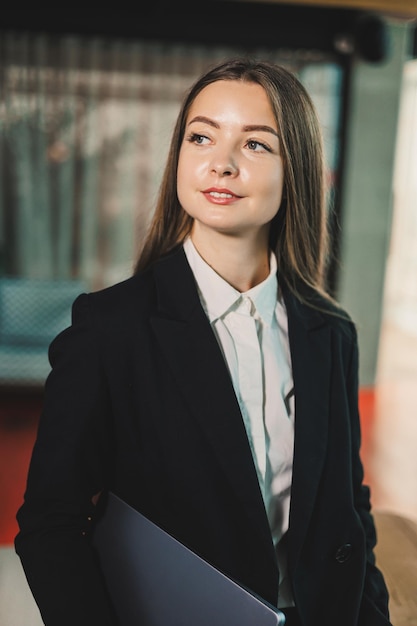 Photo portrait d'affaires d'une femme d'affaires moderne avec un ordinateur portable dans le bureau femmes d'affaires dans un costume classique noir