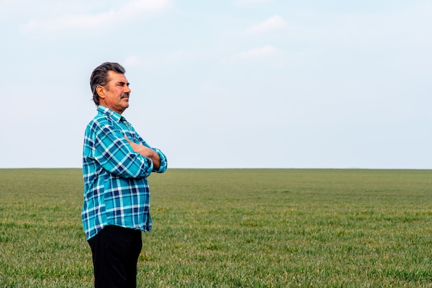 Portrait d'agriculteur debout dans un champ de blé.