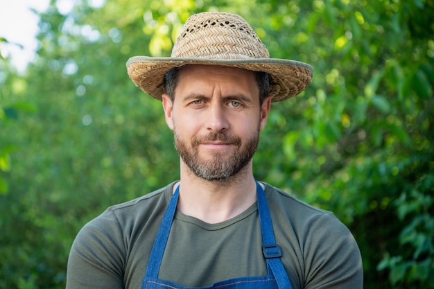 Portrait d'un agriculteur sérieux dans un chapeau d'agriculteurs à l'extérieur naturel
