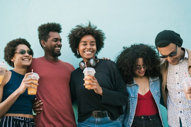 Portrait d'amis afro s'amuser ensemble et passer du bon temps tout en buvant du jus de fruits frais.