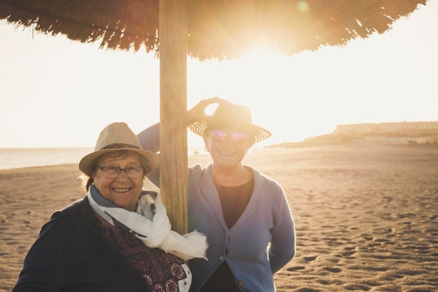Portrait d'amis heureux debout sur la plage contre un ciel clair