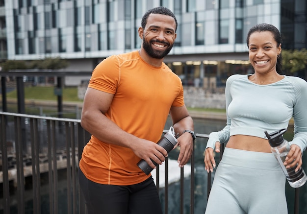 Portrait d'amis de remise en forme et d'entraînement au pont pour une pause boisson à l'eau dans la ville de Chicago USA Exercice de bien-être et personnes noires sur le repos en cours d'exécution avec bonheur d'hydratation et sourire