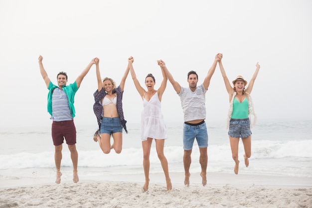 Portrait, amis, tenant mains, et, sauter, plage