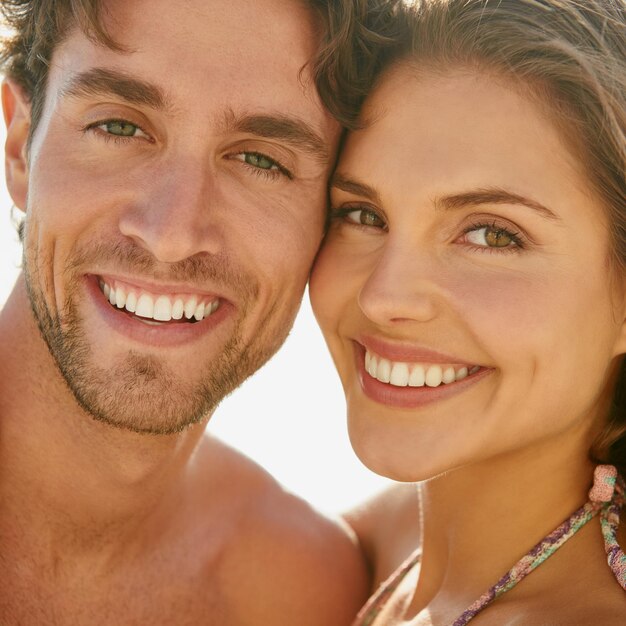 Portrait d'amour et couple heureux étreint sur une plage pour voyager vacances et se lier dans la nature ensemble aventure de l'océan et visage des gens à la mer avec soin confiance et soutien sourire et plaisir en plein air