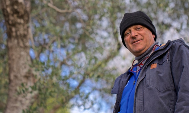 Photo portrait à angle bas d'un homme debout contre des arbres