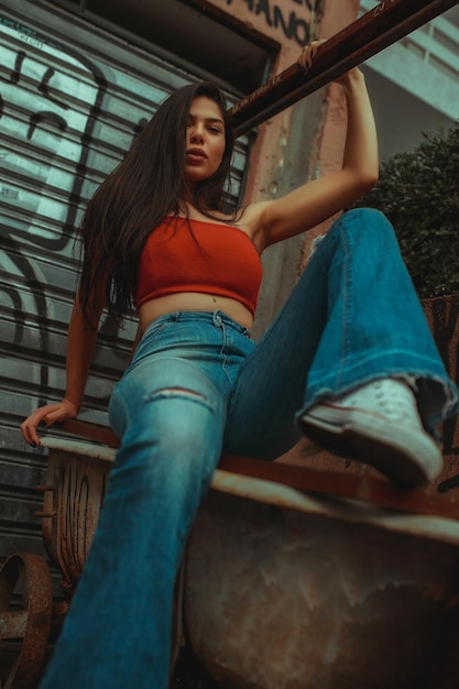 Portrait à angle bas d'une jeune femme assise sur une baignoire abandonnée